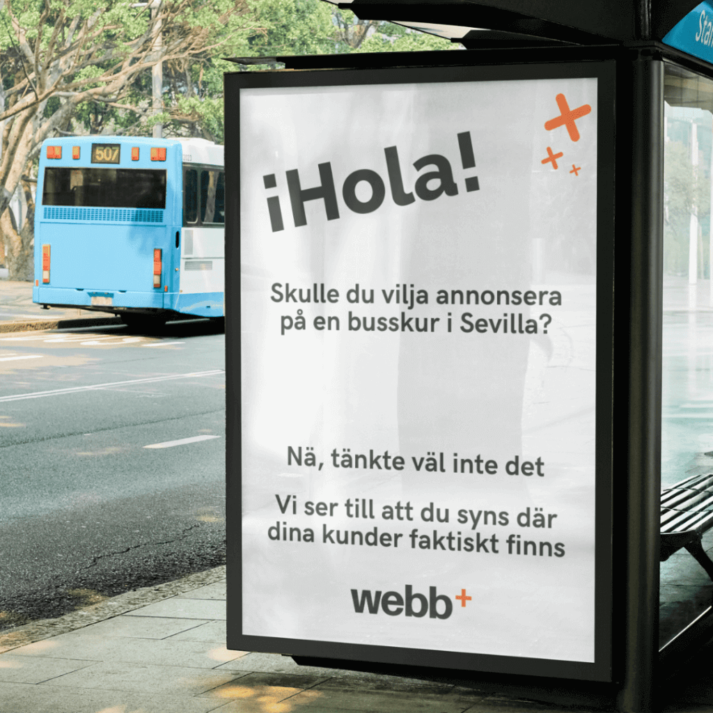 En busshållsreklam visar upp en skylt med svensk text och ett framträdande "¡Hola!" i stort teckensnitt. I bakgrunden korsar en blå buss en trädkantad gata som speglar det pulserande stadslivet. Denna kreativa visning liknar Webbyrå Norrtäljes innovativa kampanjer.